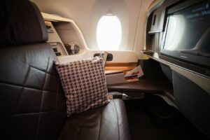 A seat in an airplane with a television on it