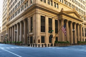 a large building with columns and a flag on the corner